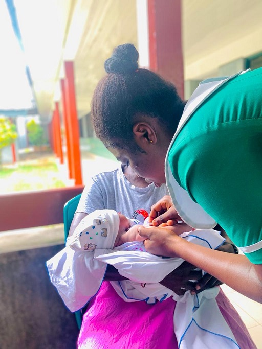Nurse attending to mother and newborn baby.